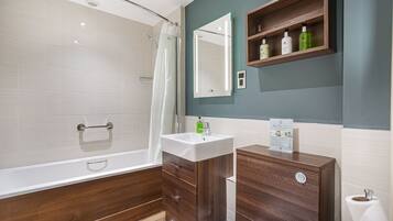 A modern bathroom with a shower, vanity, and mirror.