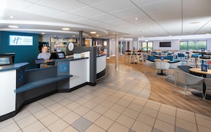 A Holiday Inn Express lobby with a reception desk, seating area, and a clock. - Holiday Inn Express Stafford by IHG (Stafford)