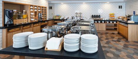 A buffet setup with multiple serving stations, a coffee machine, and a variety of food items.
