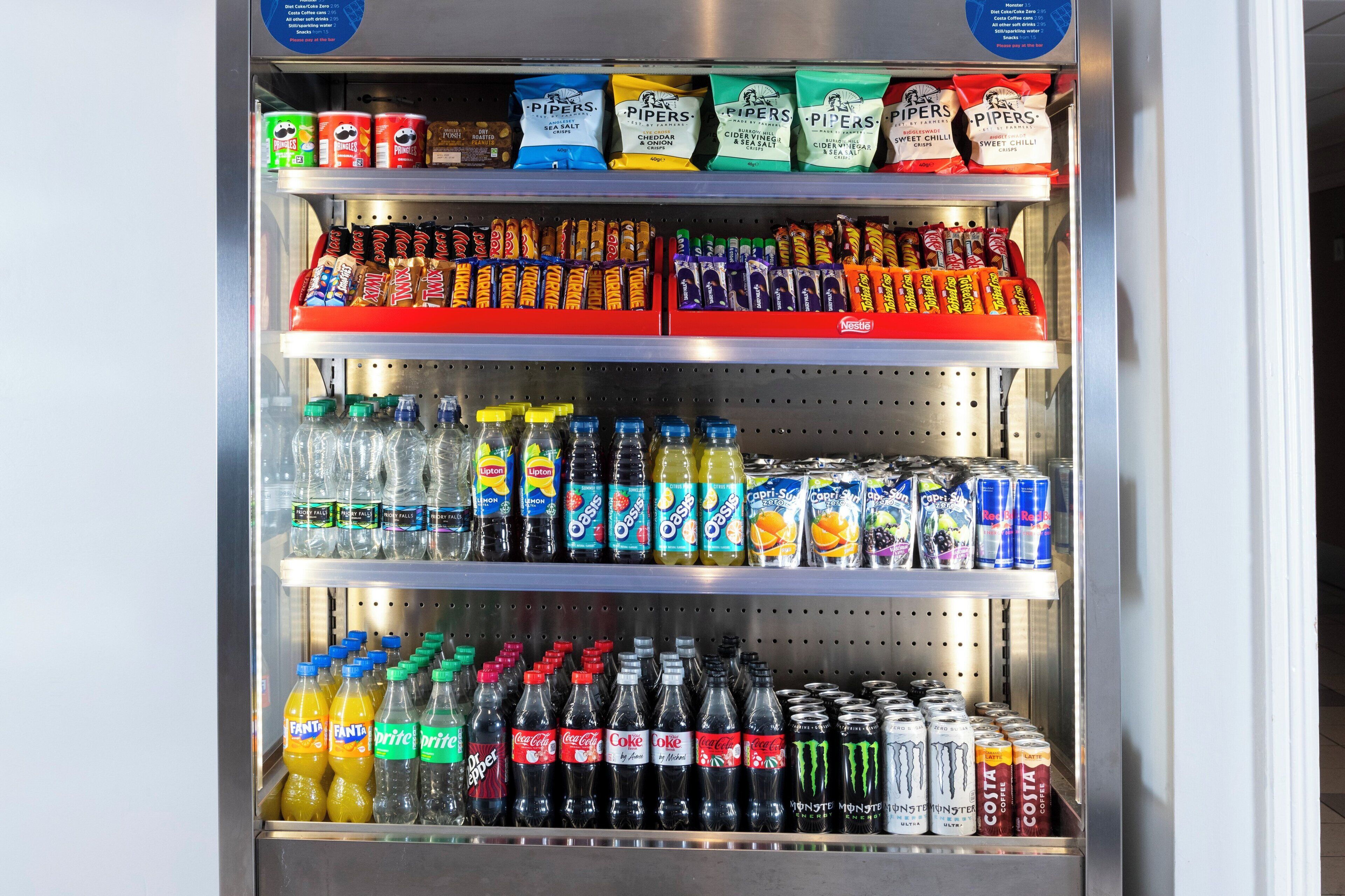Een automaat gevuld met verschillende drankjes, zoals frisdranken, vruchtensappen en energiedranken.