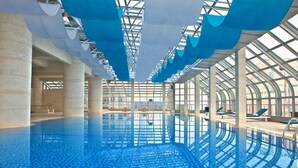 An indoor swimming pool with clear blue water, large windows, and a modern architectural design. - Sheraton Nanjing Kingsley Hotel (Nanjing)