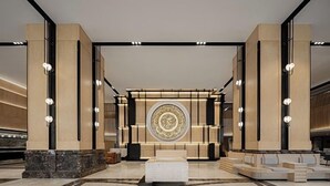 A lobby with a central seating area, a large decorative wall, and a marble floor. - Sheraton Nanjing Kingsley Hotel (Nanjing)