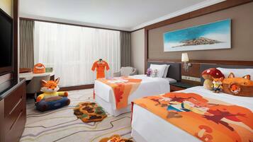 A hotel room with two beds, a TV, a desk with a chair, and a large window with curtains.