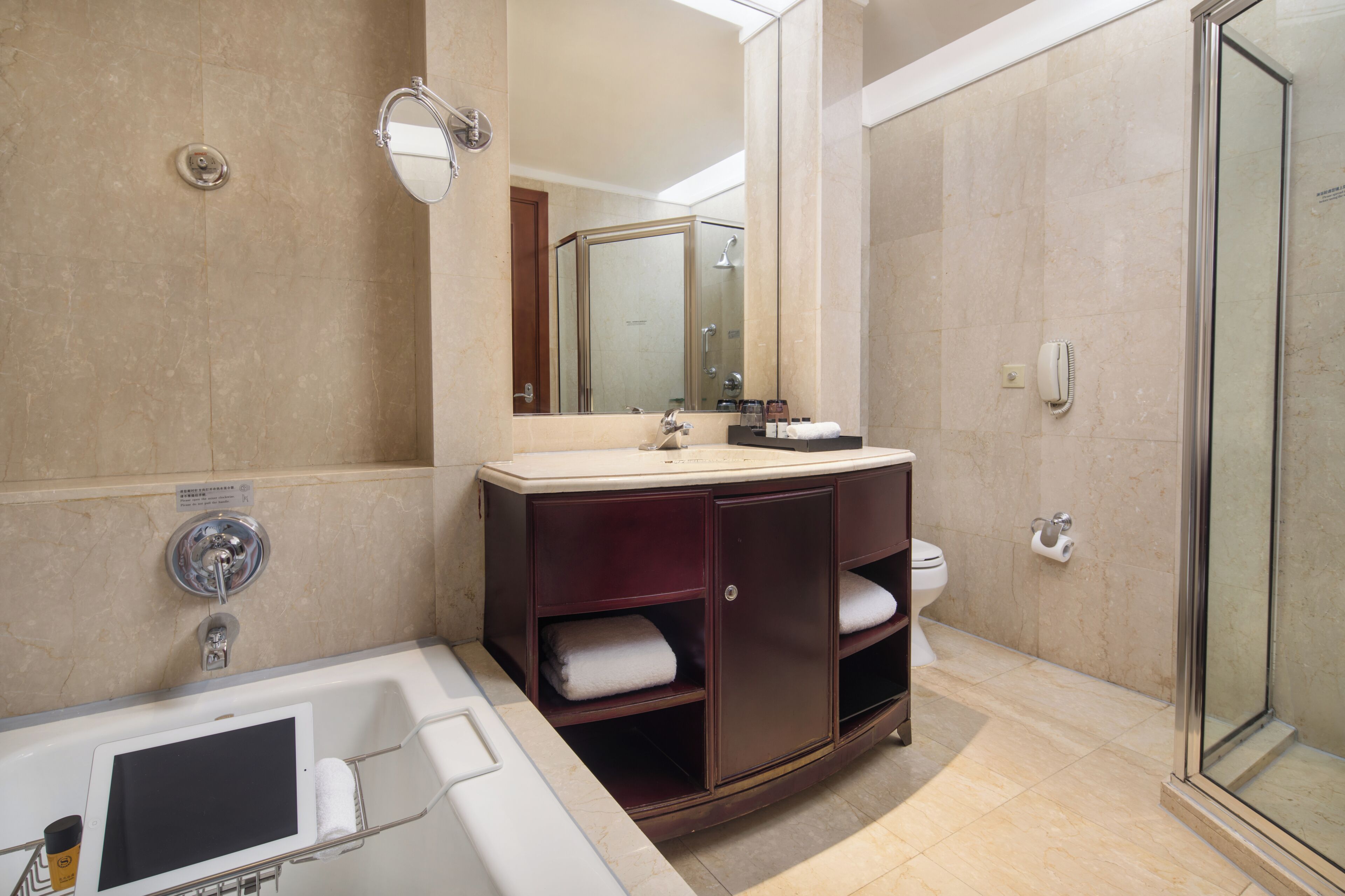 A bathroom with a bathtub, a vanity with a mirror, a toilet, and a shower area.
