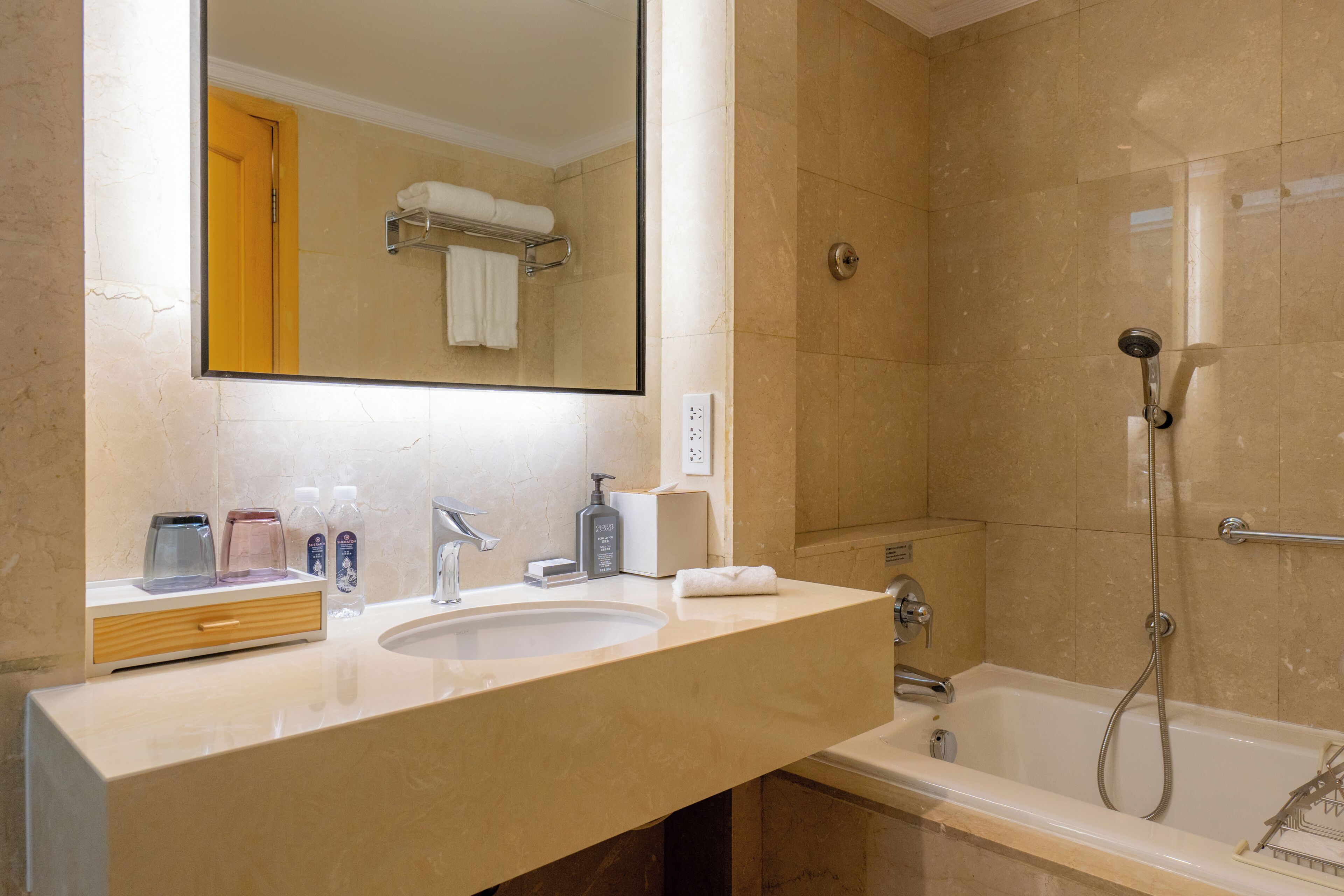 Un baño con lavamanos, espejo y ducha.