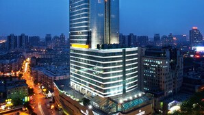 A high-rise building with a modern glass facade, multiple floors, and a prominent sign at the top. - Sheraton Nanjing Kingsley Hotel (Nanjing)