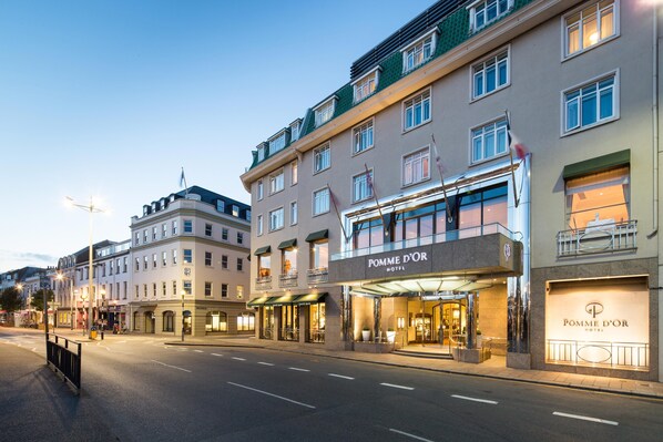 A hotel with a prominent entrance, multiple floors, and a well-lit facade.