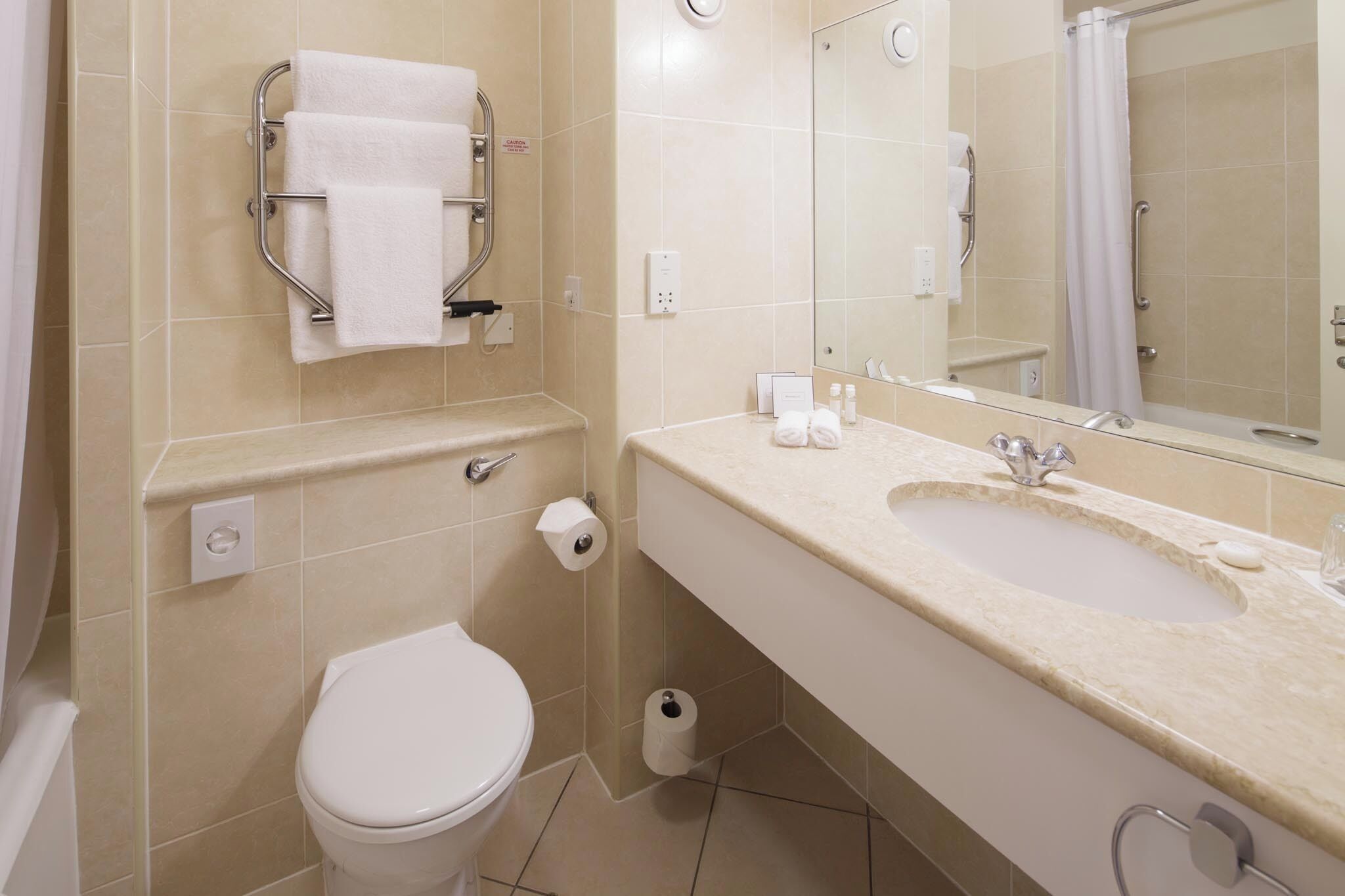 Un baño con inodoro, lavamanos y espejo.