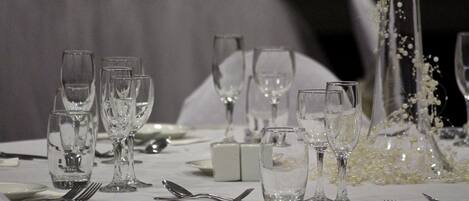 Una mesa dispuesta para una cena formal, con varias copas de vino, platos y cubiertos.