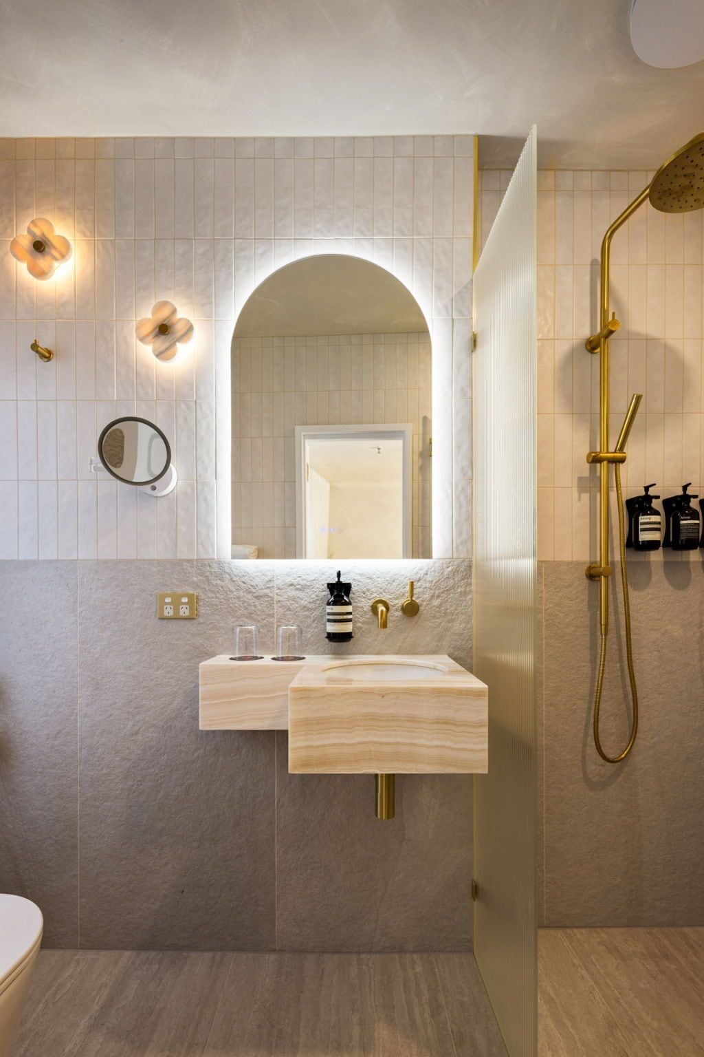 A modern bathroom with a vanity, a large mirror, and a shower.