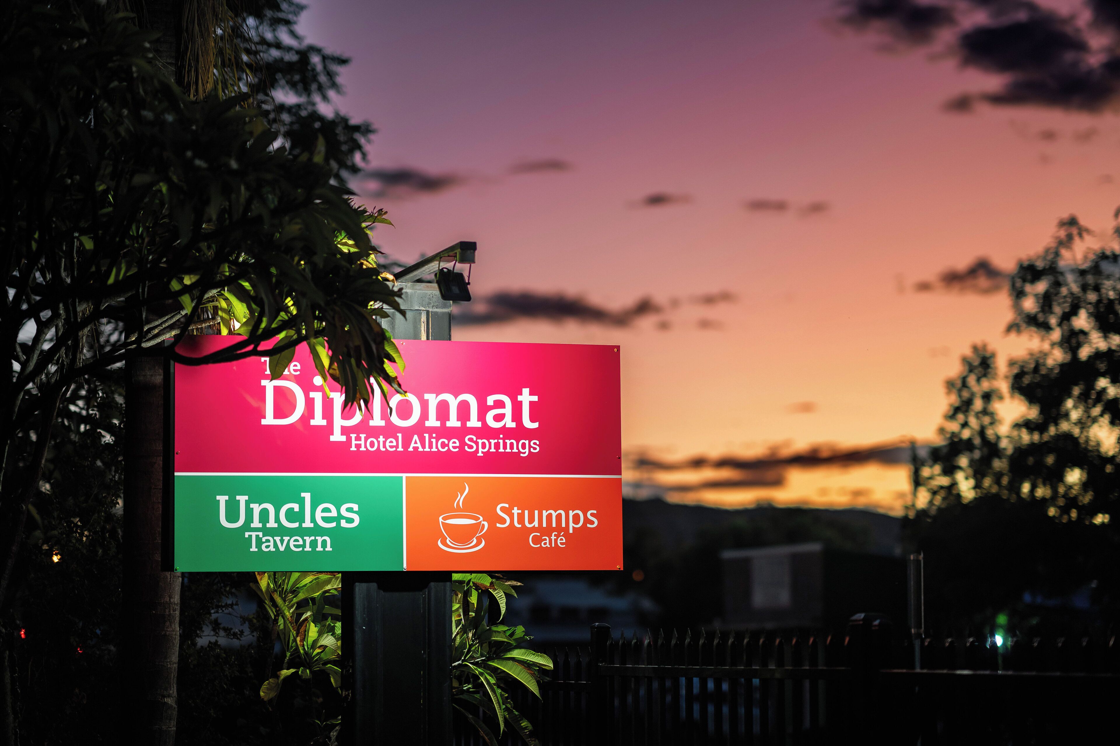 A sign for the Diplomat Hotel Alice Springs, featuring the Uncles Tavern and Stumps Café.