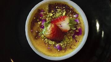 Un postre en un tazón blanco sobre fondo oscuro.