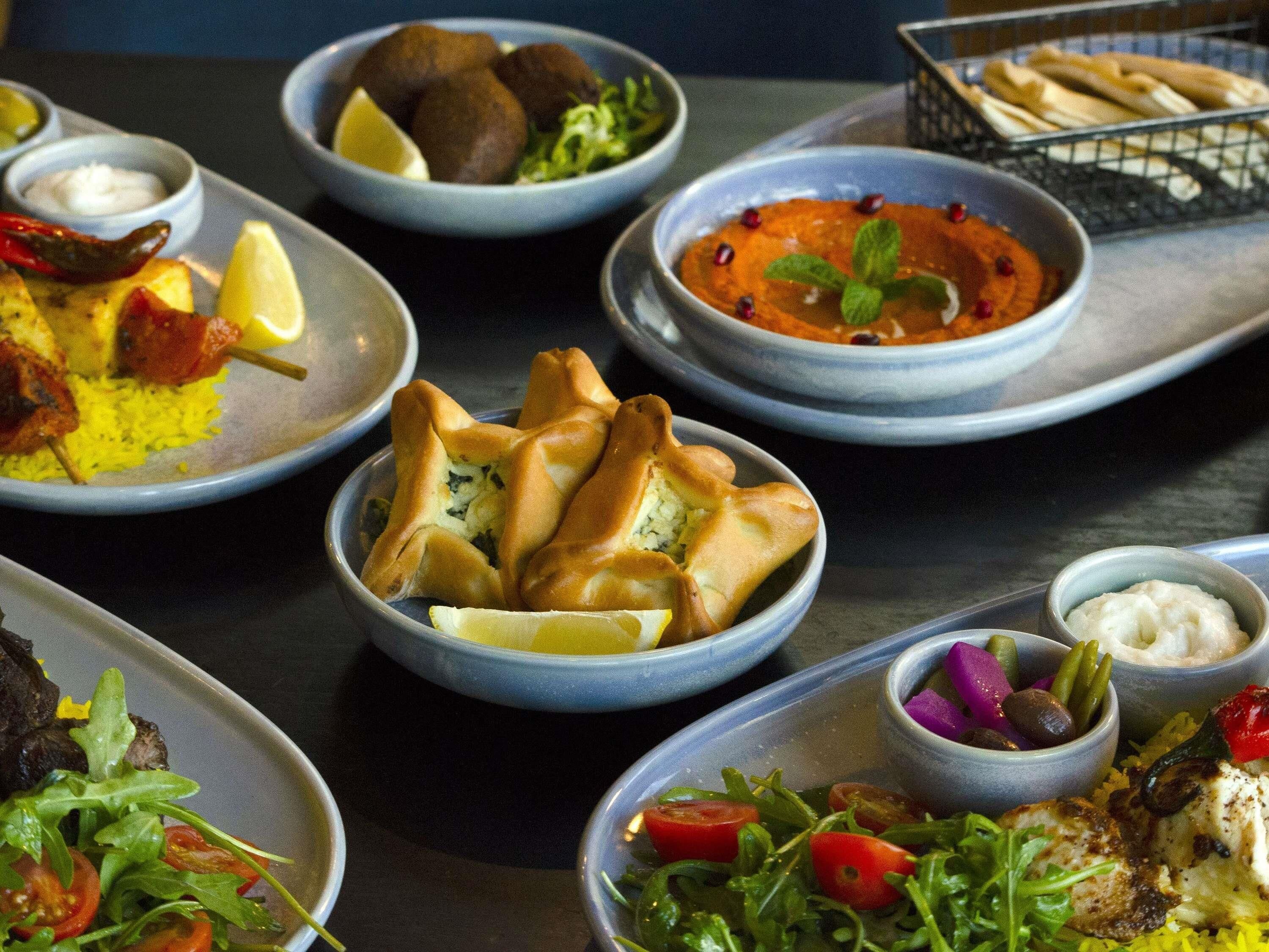 A variety of dishes including kebabs, rice, and salads, suggesting a diverse meal selection.
