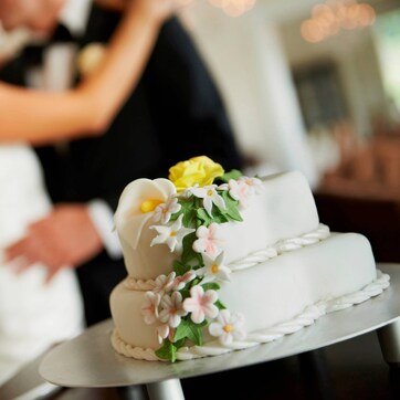 A wedding cake with floral decorations on a cake stand.