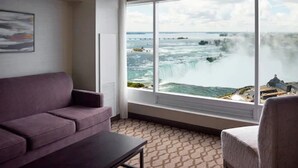 A room with a large window overlooking a waterfall, a purple sofa, and a patterned floor. - Marriott Niagara Falls Fallsview Hotel & Spa (Niagara Falls)