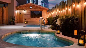 A spa area with a hot tub, wooden deck, and a view of a casino building.
