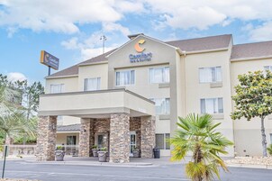 Un hotel Comfort Inn & Suites con fachada de piedra, varias ventanas y un acceso cubierto.
