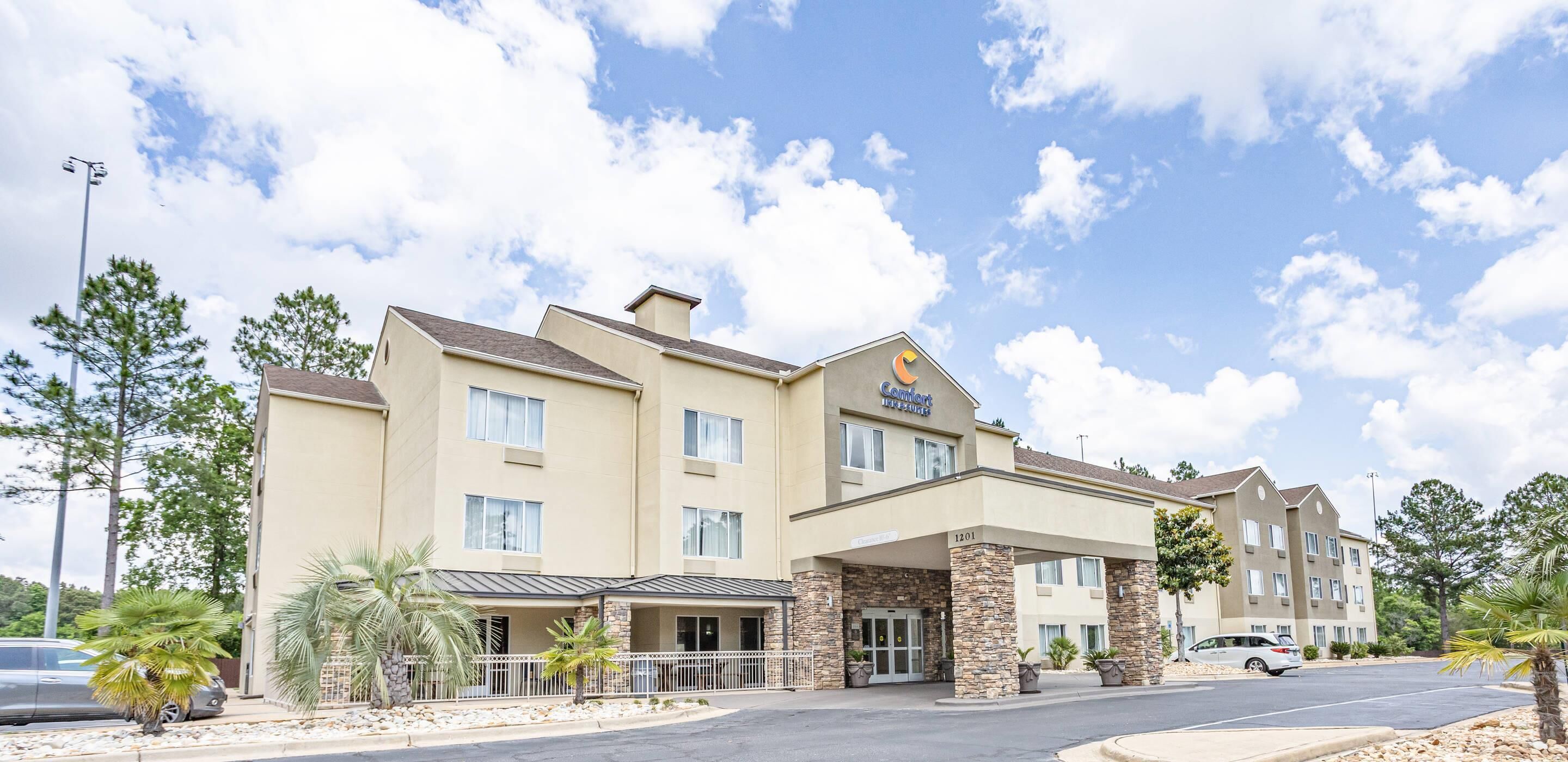 A hotel with a two-story structure, a covered entrance, and a parking area.