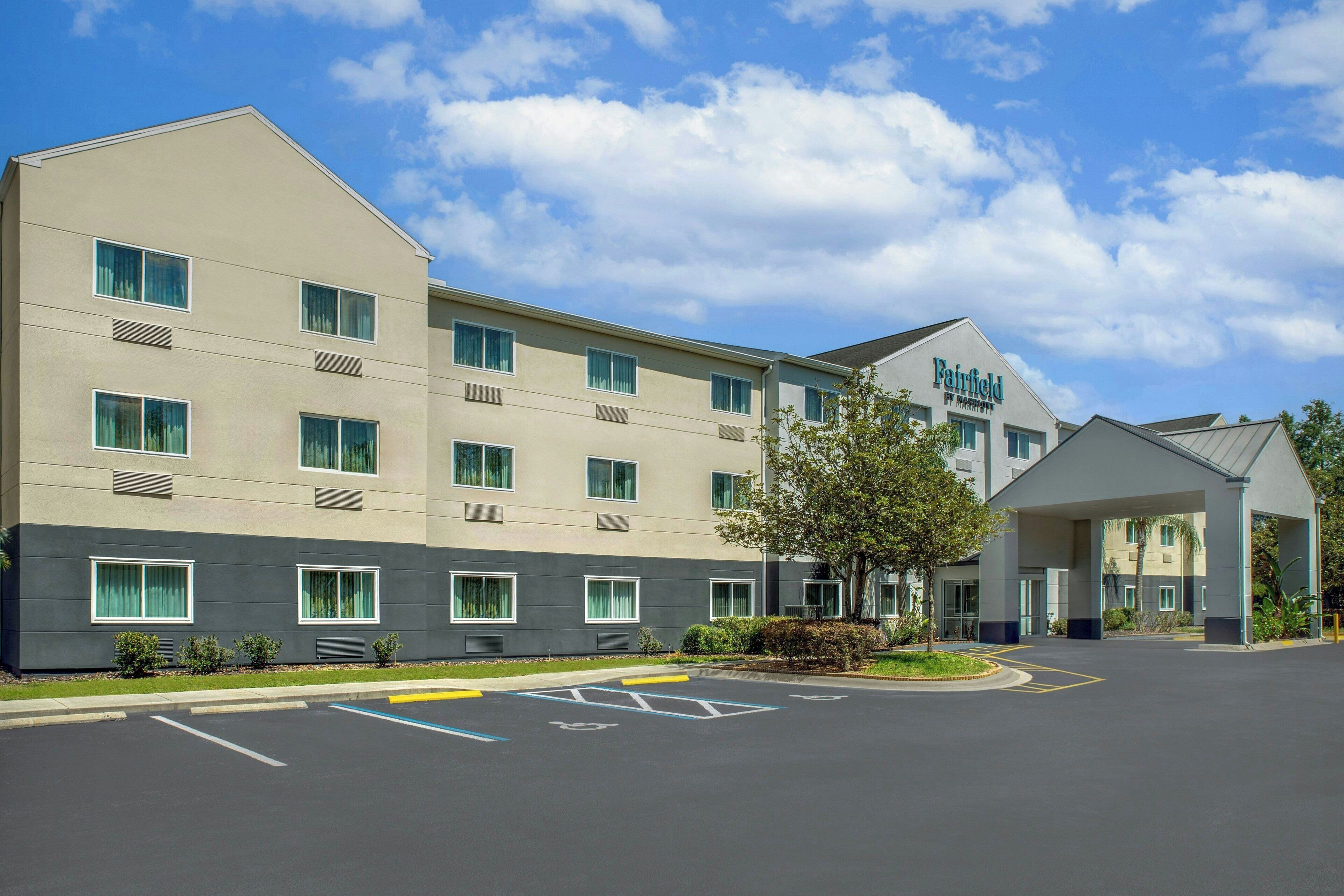 A Fairfield by Marriott hotel with a modern facade, multiple windows, and a parking lot with handicapped parking spaces.