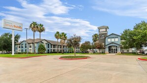 A hotel with a central building, a smaller annex, and a parking area. - Sonesta Simply Suites Stafford (Stafford)