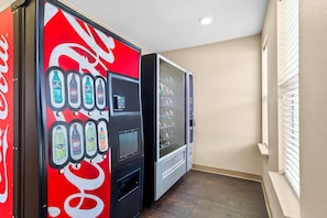 A vending machine with various drink options and a microwave. - Sonesta Simply Suites Stafford (Stafford)