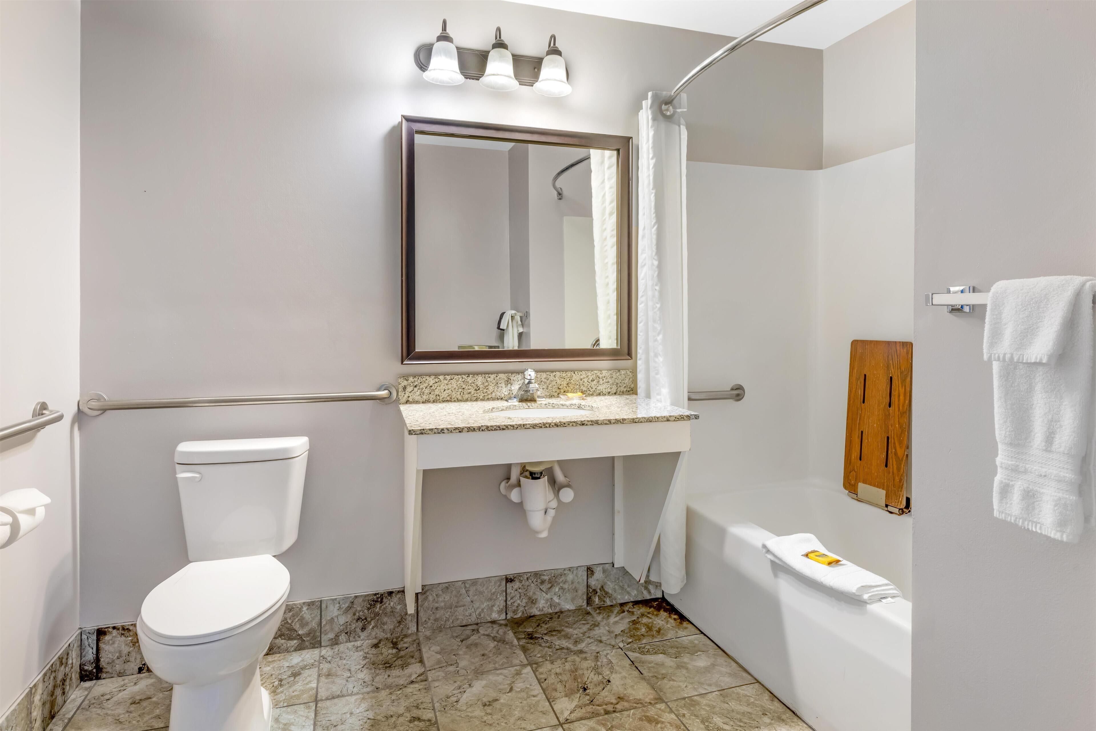 A bathroom with a toilet, sink, mirror, shower, and bathtub.