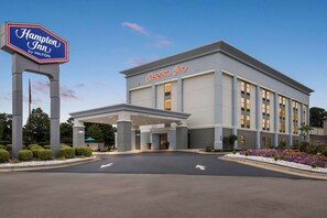 A Hampton Inn by Hilton with a modern facade, a covered entrance, and a landscaped area with flowers. - Hampton Inn Florence Midtown near University of North Alabama (Florence)