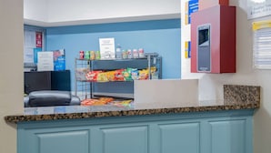 A reception area with a counter, a seating area, and vending machines. - Days Inn by Wyndham Hamilton (Hamilton)