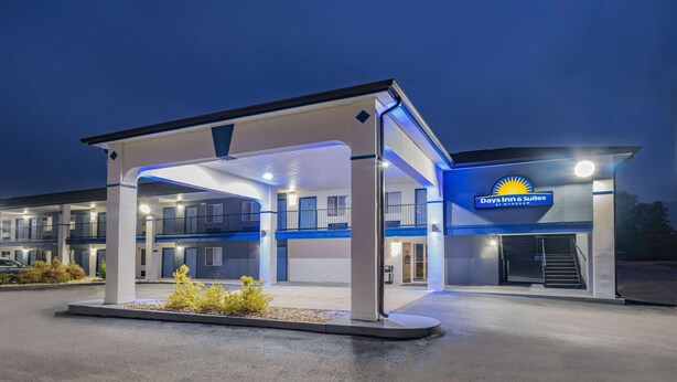 A Days Inn & Suites with a covered parking area, multiple floors, and a visible staircase leading to the entrance.