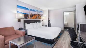 Une chambre d’hôtel avec un grand lit, un canapé, un bureau et une télévision.