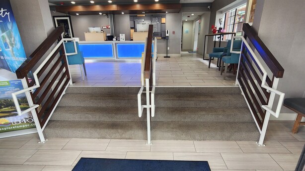 A hotel lobby with a reception desk, seating area, and a staircase leading to upper floors. - Holiday Inn Express Lompoc by IHG (Lompoc)