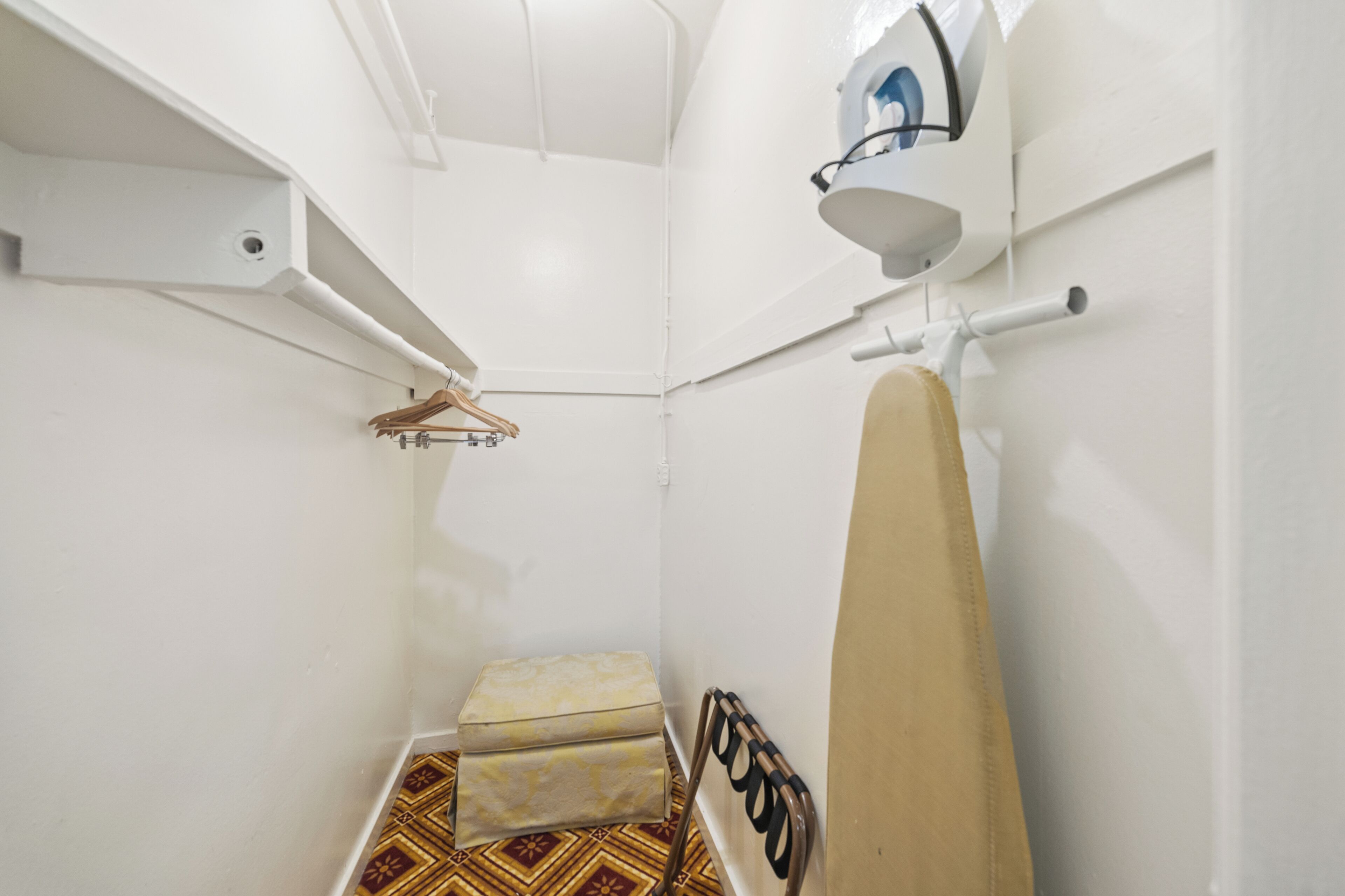 A small, compact bathroom with a shower, a towel rack, and a hanging towel.