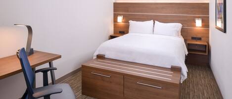 A hotel room with a bed, bedside tables, a desk, and a chair.
