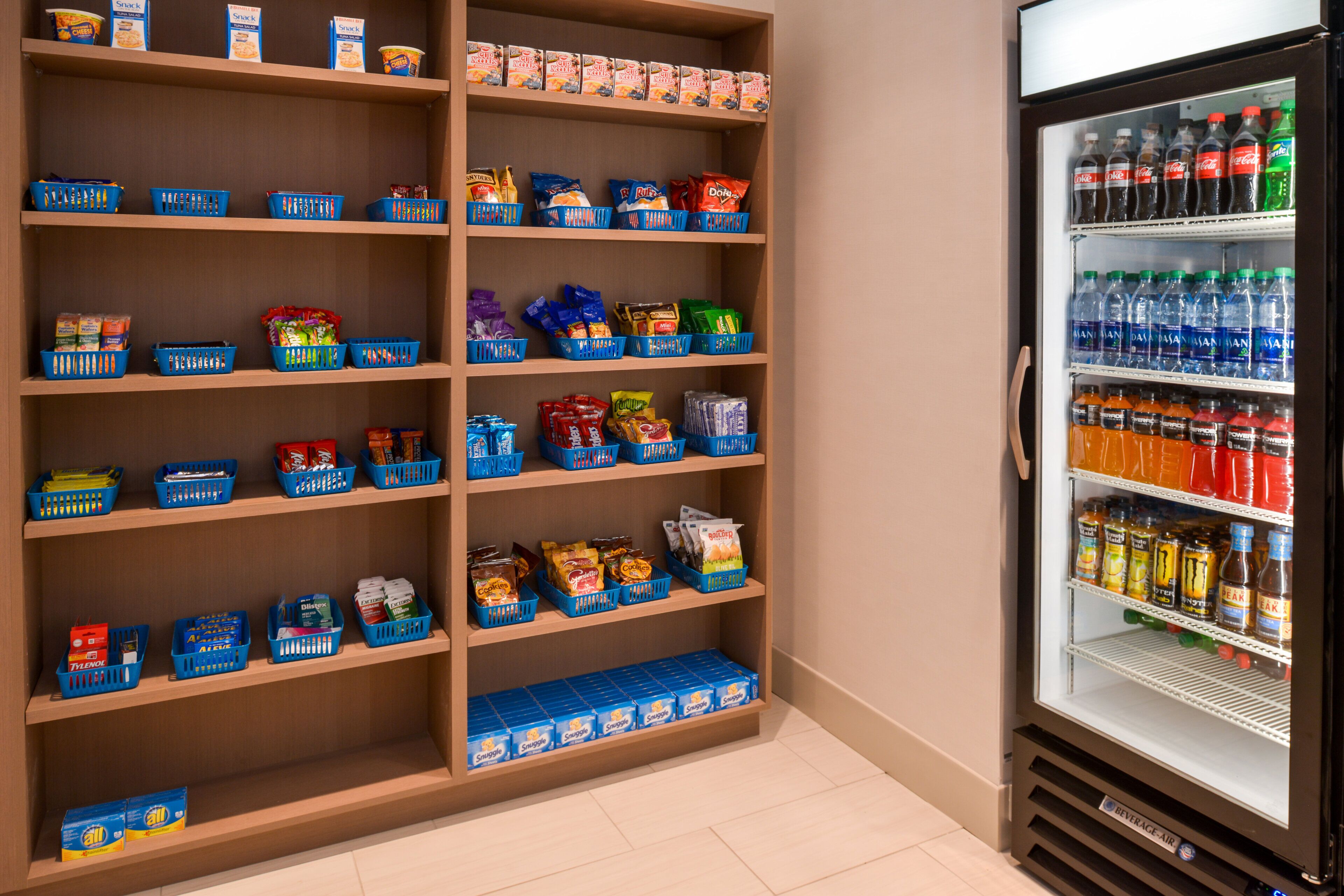 Un refrigerador con aperitivos y bebidas, repleto de diversas opciones.