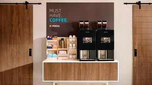 A coffee station with two coffee machines and a display of coffee products. - Holiday Inn Express Glenwood Springs by IHG (Glenwood Springs)