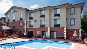 Edificio de Holiday Inn Express con piscina, asientos al aire libre y un cartel que dice 'No Diving'.
