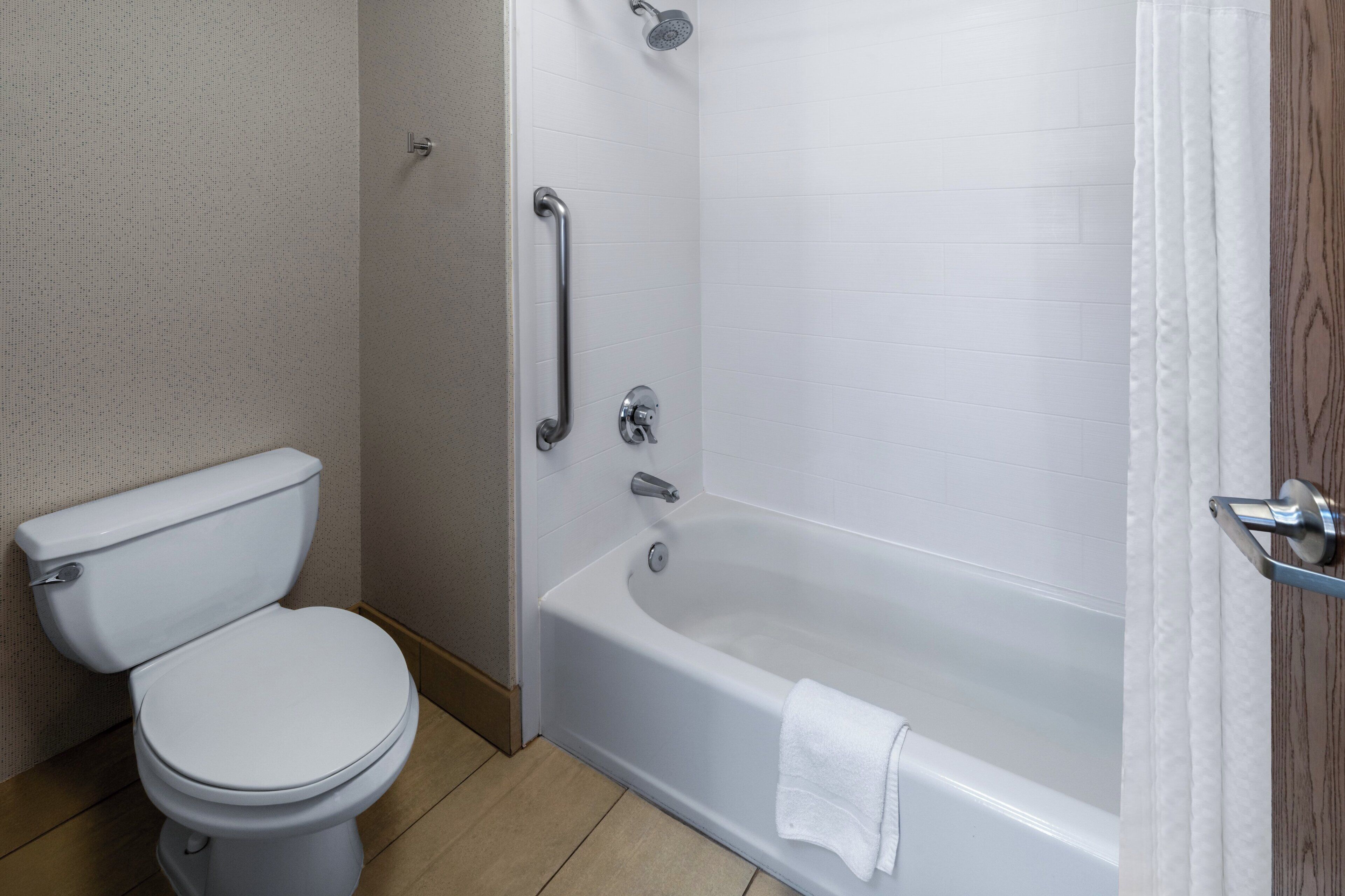 A bathroom with a toilet, a bathtub, and a shower.