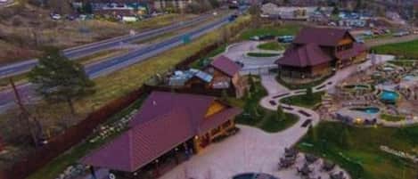 A resort with a swimming pool, guest rooms, and a mountainous backdrop.