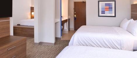 A hotel room with two beds, a wooden dresser, a flat-screen TV, and a framed abstract art piece on the wall.
