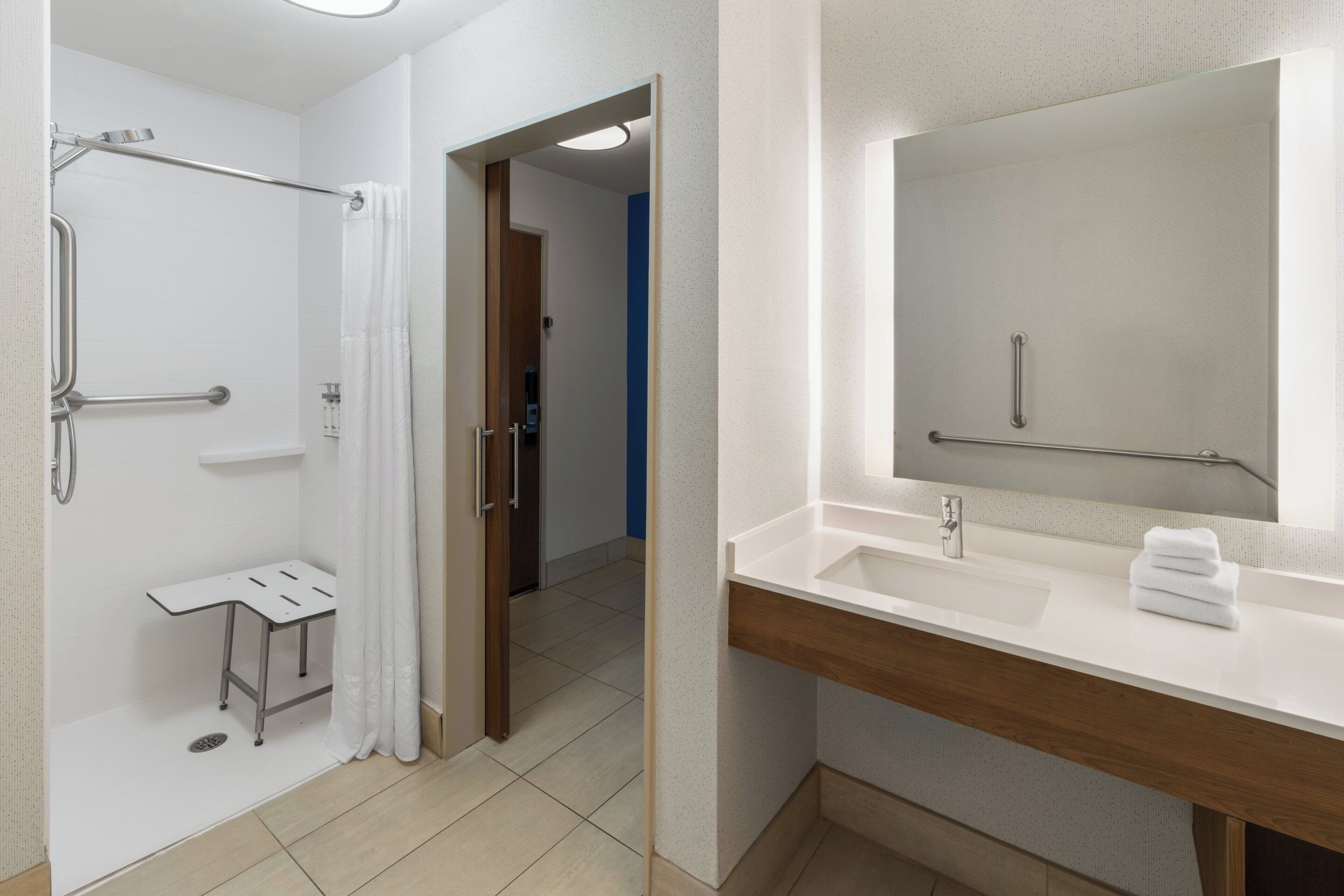 A modern bathroom with a shower, toilet, and sink.