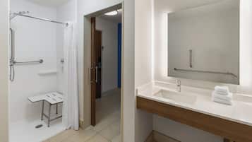 A modern bathroom with a shower, toilet, and sink.