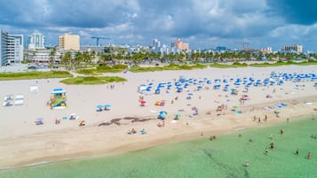 A beach with numerous umbrellas and people.
