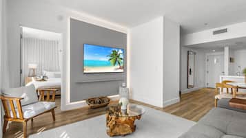 A modern living room with a flat-screen TV, a wooden coffee table, and a sofa.