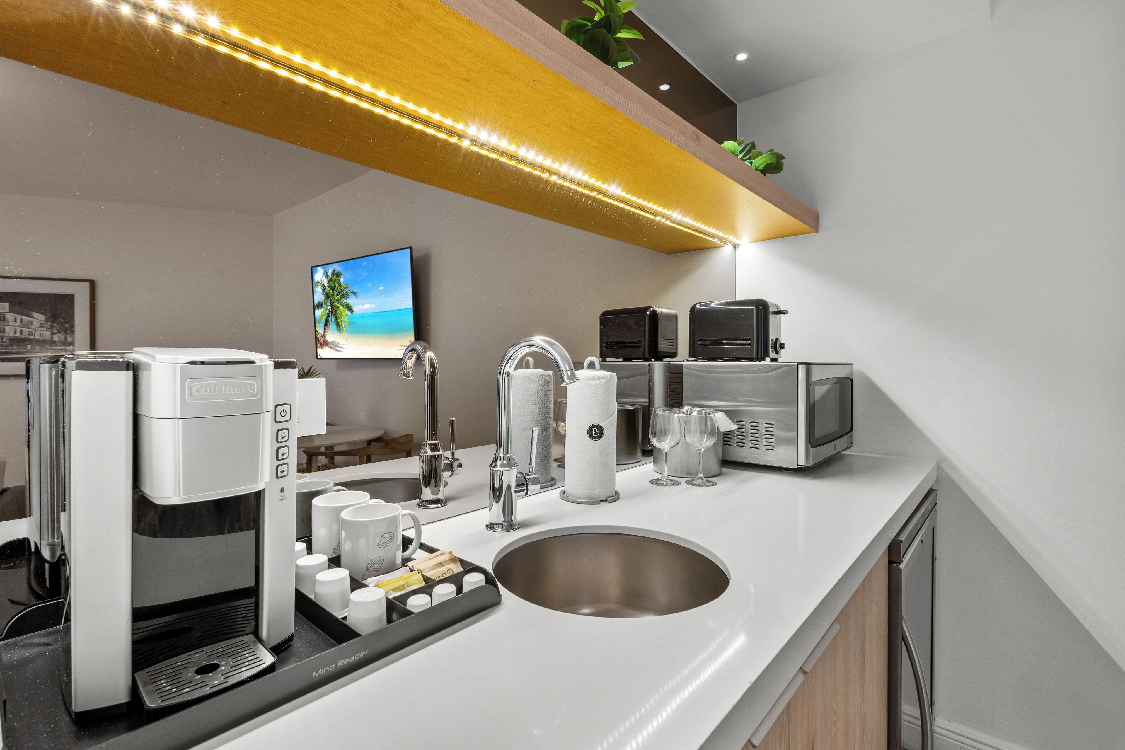 A modern kitchen with a coffee maker, microwave, and sink.