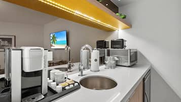 A modern kitchen with a coffee maker, microwave, and sink.