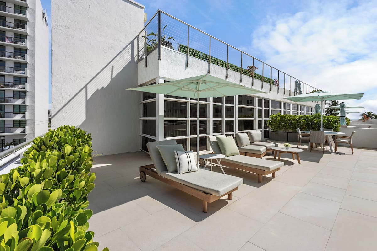 Une terrasse sur le toit, équipée de chaises longues, d’une table et de chaises.