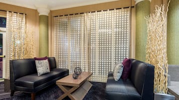 Una sala de estar moderna con dos sofás, una mesa de centro de madera y elementos decorativos.
