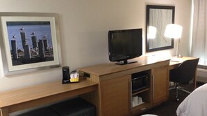 A hotel room with a bed, a desk with a computer and lamp, a coffee maker, a microwave, and a framed picture on the wall. - Hampton Inn Tampa/Rocky Point-Airport (Tampa)