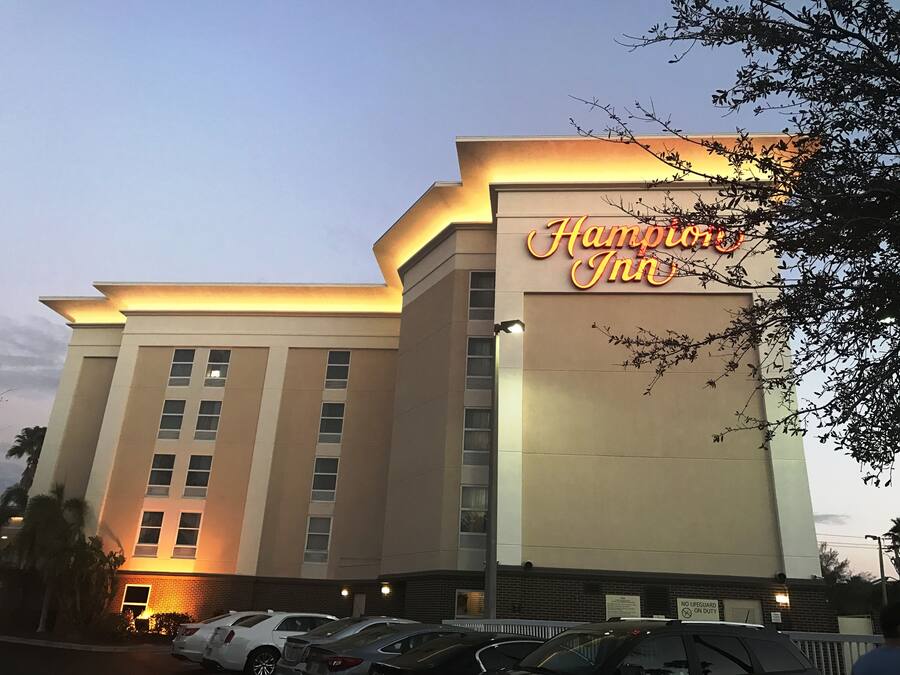 A hotel with a prominent neon sign reading "Hampton Inn."