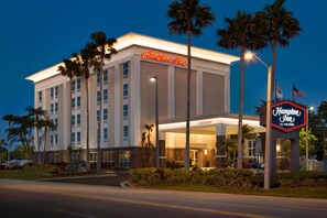 A Hampton Inn hotel with a well-lit entrance, palm trees, and a clear night sky. - Hampton Inn Tampa/Rocky Point-Airport (Tampa)